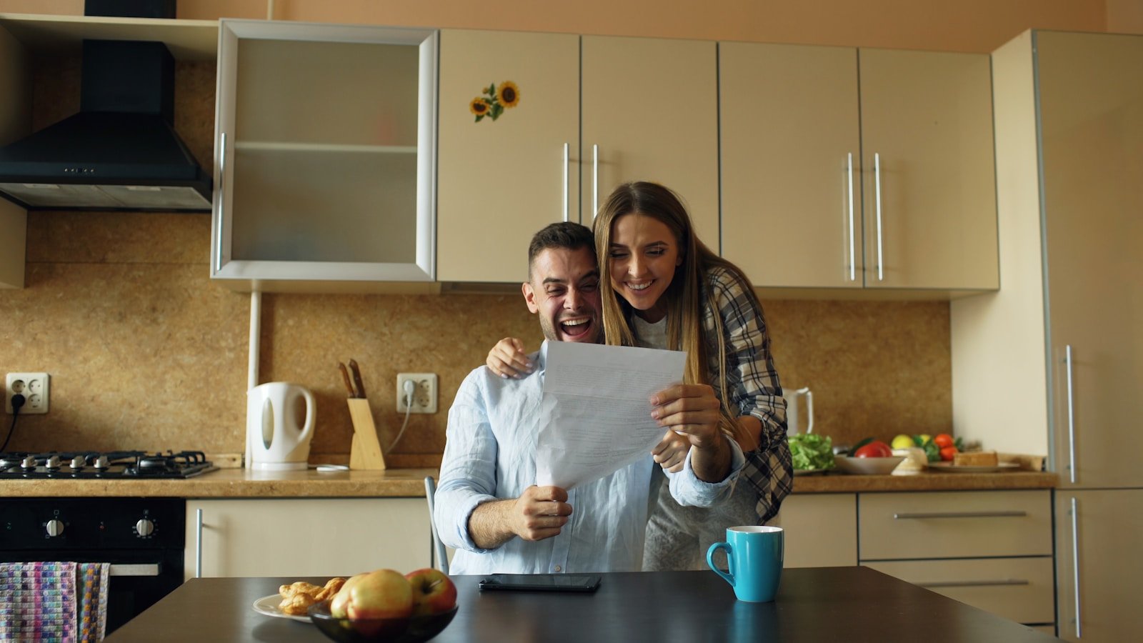 Couple excitedly looking at a document in kitchen